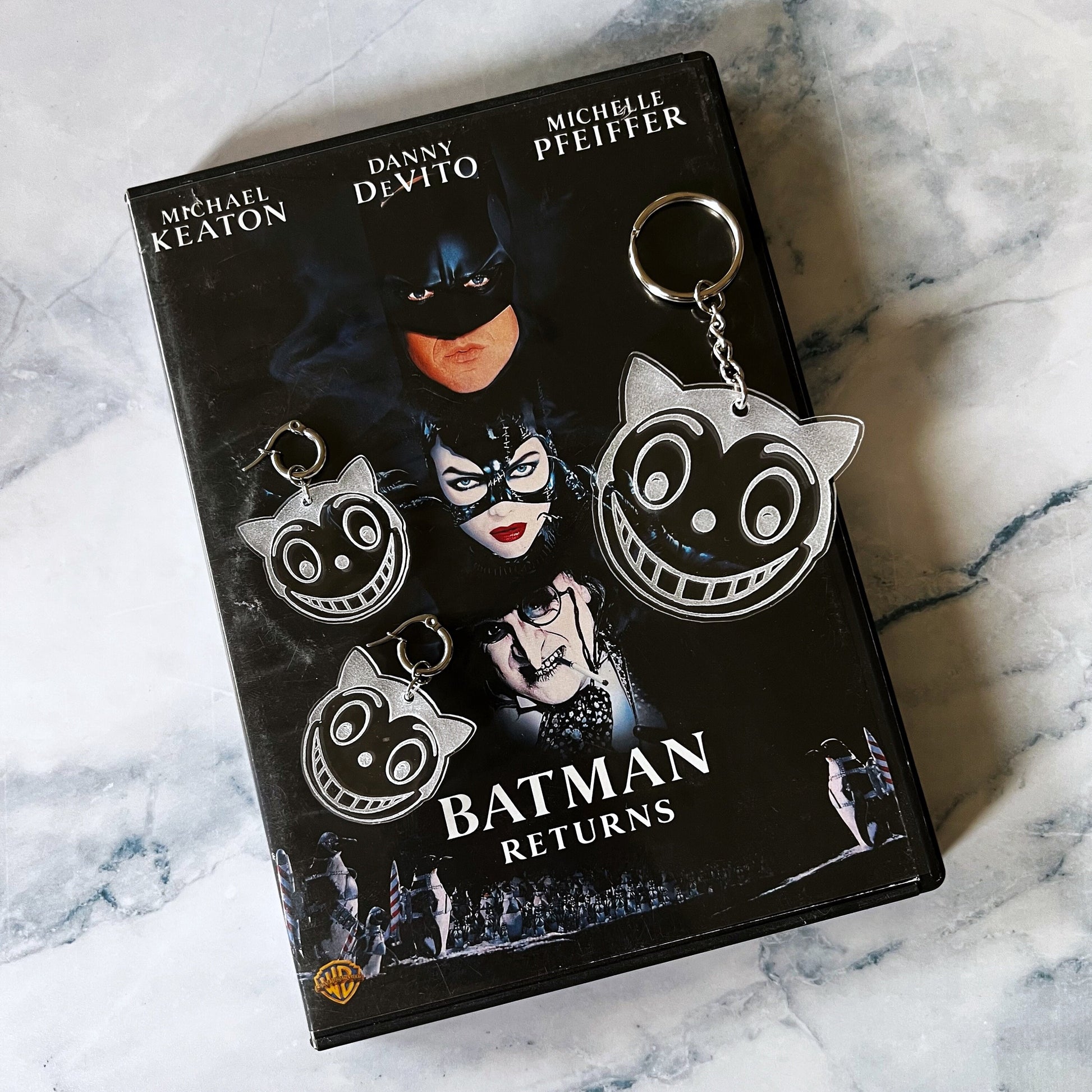 Shreck Cat-inspired earrings and keychains from Batman Returns.