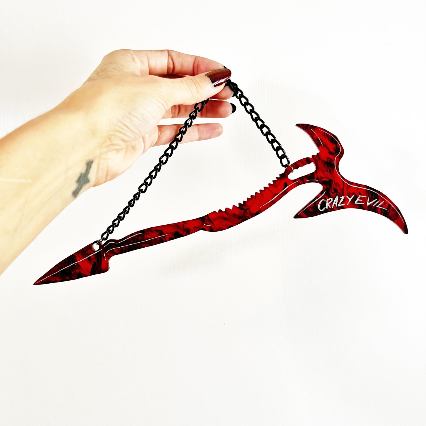 Mandy Movie Merch - A Replica of the weapon from the film, called "The Beast". Large red and black swirled syth-axe hybrid hanging from a black chain.